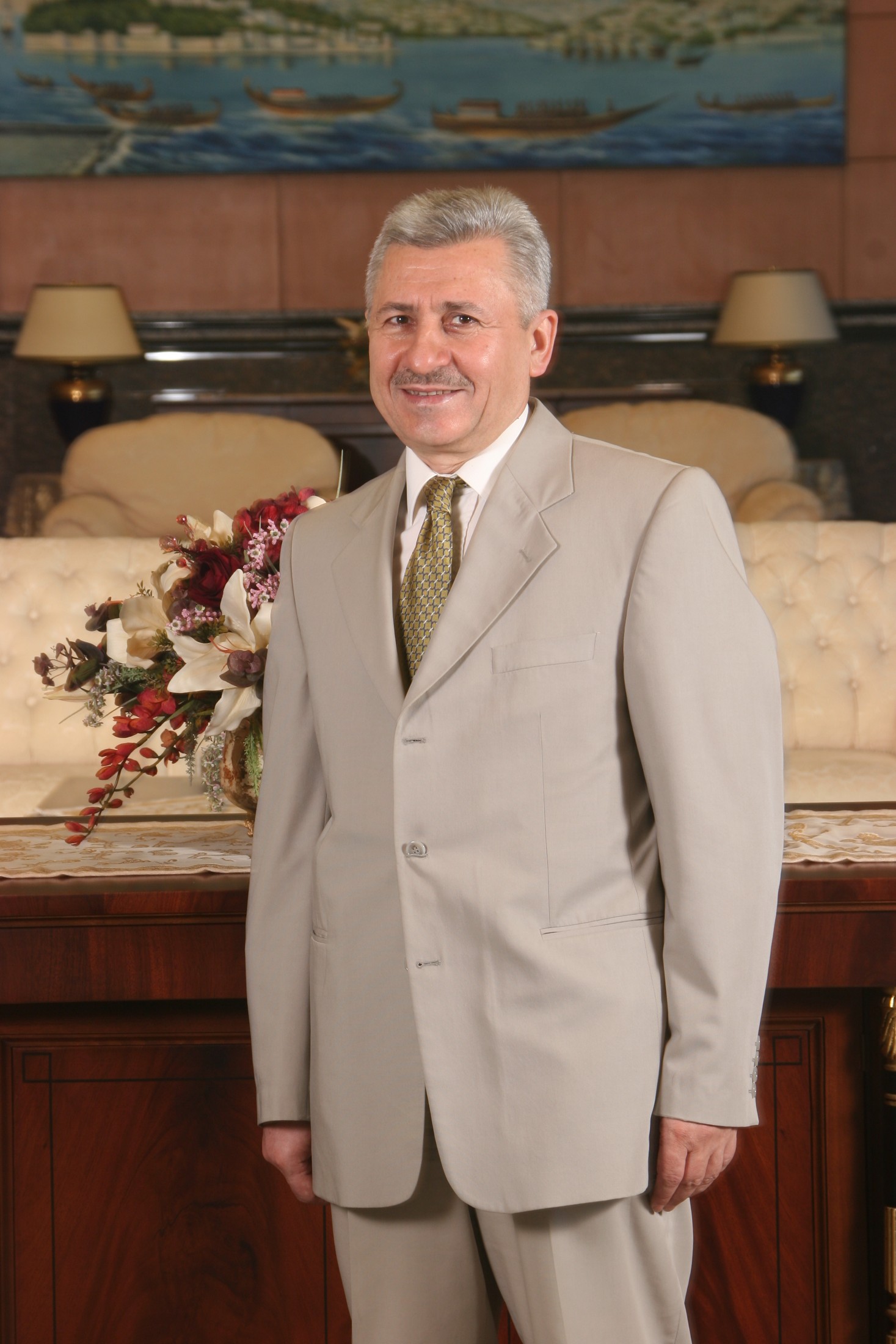 Mehmet Oruç açık renk takım elbisesiyle ayakta